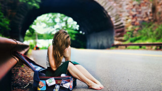 Woman sitting road suitcase tunnel - a suitcase in front free wallpaper