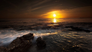 Sunset ocean waves rocks boat 2 - free beach wallpaper