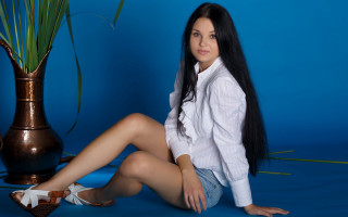 Woman sitting vase plant blue - a blue background behind her free wallpaper
