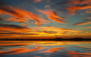 Sunset clouds reflecting water boat - a small island in the distance free wallpaper