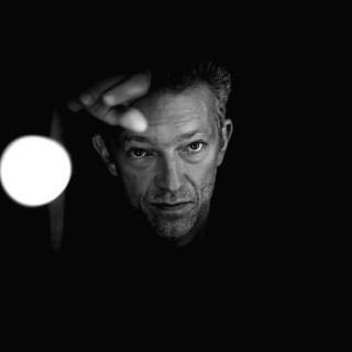 Man looking camera dark light - free light wallpaper for tablet