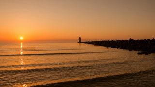 Sunset ocean boat lighthouse horizon - a light house in the distance free wallpaper
