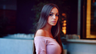 Woman pink top outside bokeh - a plant behind her free wallpaper