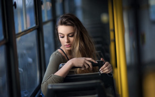 Woman sitting bus cellphone suitcase - a bus free wallpaper