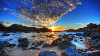 Sunset rocky beach water clouds - a sunset over a rocky beach free wallpaper