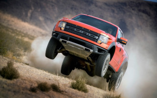 Red truck jumping hill dust - a red truck free wallpaper