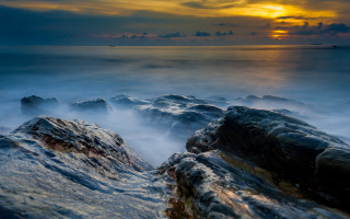 Rocky beach sunset water boat - long exposure free wallpaper