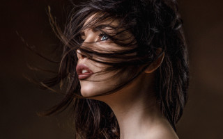 Woman blowing hair blue eyes 5 - a brown background free wallpaper