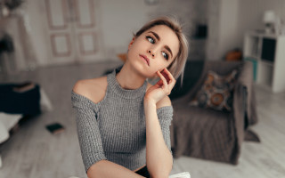 Woman sitting bed gray sweater - a white floor free wallpaper