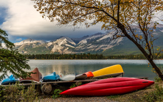 Canoes lake mountains cloudy sky - the shore of a lake free wallpaper
