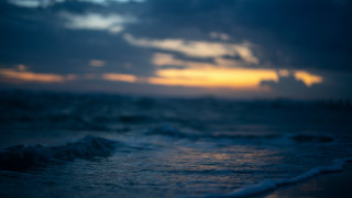 Blurry ocean sunset waves boat - a boat in the distance free wallpaper