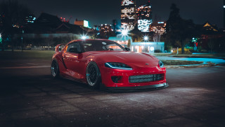 Red sports car night city 9 - a city skyline in the background free wallpaper