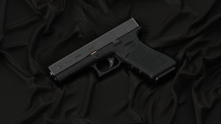 Black gun on wrinkled cloth - 30mm free wallpaper