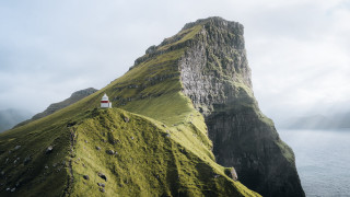 Lighthouse grassy hill ocean mountain - a mountain in the background and a body of water free wallpaper