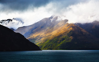 Mountain lake clouds boat night - dramatic light free wallpaper
