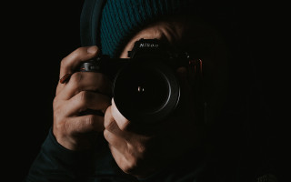 Man holding camera dark hat - nikon free wallpaper