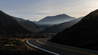 Mountain road sunset clouds forest - a sunbeam in the distance free wallpaper