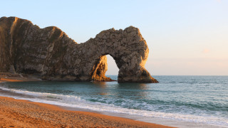 Beach rock formation waves sunset - the shore and a person free wallpaper