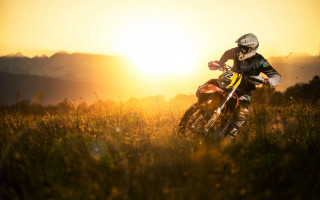 Dirt bike riding grassy field - the background and sun free wallpaper