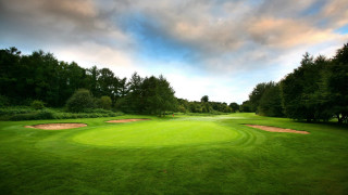Green golf course hole cloudy 2 - a hole in the middle of it free wallpaper