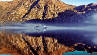 Boat mountain mist city night - the water near a mountain range free wallpaper