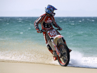 Man riding dirt bike beach - sandy free wallpaper