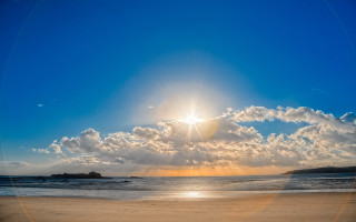 Beach sunshine clouds person surfboard - the beach in the distance free wallpaper