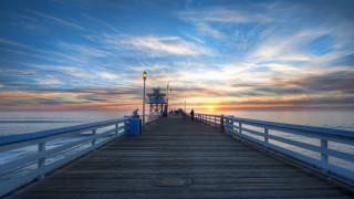 Pier lighthouse sunset ocean clouds - a light pole free wallpaper