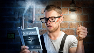 Bald man holding light bulb - a brick wall behind free wallpaper