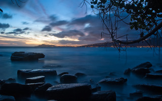Lake rocks city clouds twilight - long exposure free wallpaper