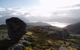 Rock formation grassy hill lake - a lake in the distance free wallpaper