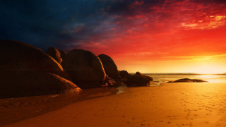 Sunset beach rocks water mountain 3 - a sunset over a beach free wallpaper