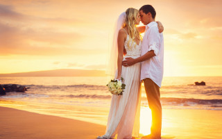 Beach sunset romantic couple kiss - the sun setting behind them free wallpaper