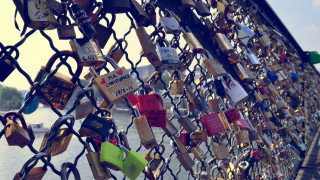 Fence padlocks locks river boats - a river in the background free wallpaper