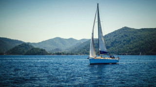 Sailboat lake mountains blue sky - a sailboat free wallpaper