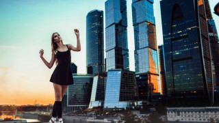 Woman black dress cityscape sunset - a ledge in front free wallpaper