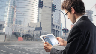 Man suit holding tablet city - a tablet computer free wallpaper