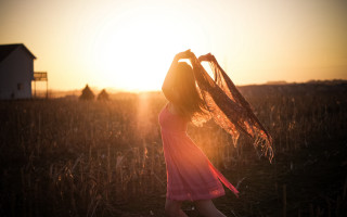 Pink dress woman sunset field - a house in the background free wallpaper for desktop