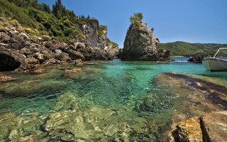 Boat rocky shore mountain lake - a small island in the background free wallpaper