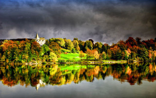 Lake church trees dark sky - a hill in the background and trees free wallpaper