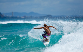 Woman surfing ocean city sky - top of a surfboard in the ocean free wallpaper