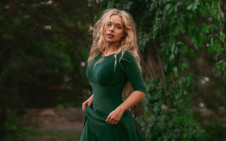 Woman green dress forest blurry 2 - tree and bushes behind her free wallpaper