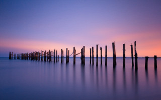 Poles water sunset purple sky - a purple sky in the background free wallpaper for desktop
