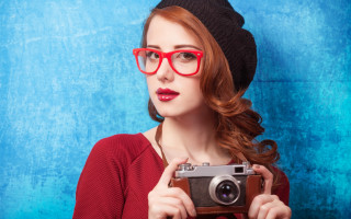 Woman glasses hat camera blue - a blue background behind her free wallpaper