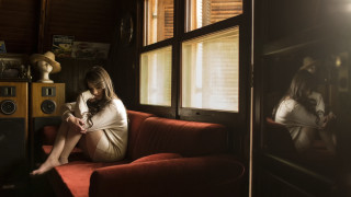 Woman sitting red couch indoor - somber free wallpaper