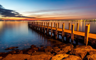 Pier rocky shore sunset city - a long pier free wallpaper