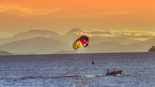 Paragliding ocean mountains sunset saturated - a parachute free wallpaper