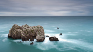 Rock formation ocean clouds sky 2 - a rock formation in the ocean free wallpaper