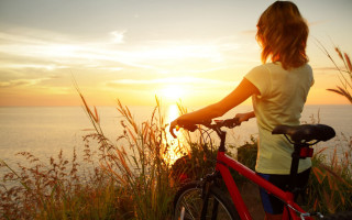 Woman bike ocean sunset scenery - the sun setting free wallpaper for desktop