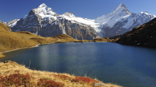 Mountain lake grassy snowy horizon - mountain in the background free wallpaper